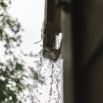 A closeup, blurry image of water overspilling a gutter.