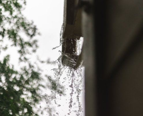 A closeup, blurry image of water overspilling a gutter.